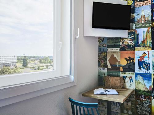 a room with a desk with a window and a tv at hotelF1 Roissy CDG Pn2 in Roissy-en-France