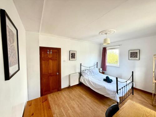Un dormitorio con una cama y suelo de madera. en Spacious 3 Bedroom Flat, en Edimburgo