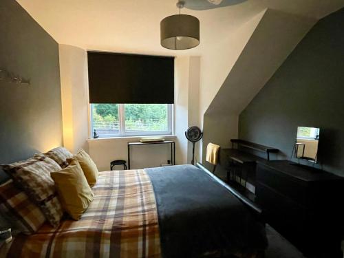 a bedroom with a bed and a piano and a window at Foundry Street Apartment 3 - Dunfermline City Centre in Dunfermline