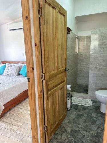 a bathroom with a wooden door leading to a bedroom at Sunset Villa - Stunning Poolside in Sámara