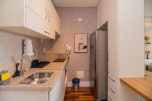 a kitchen with a sink and a refrigerator at Roma Studio - Elegante & Aconchegante no Brooklin in Sao Paulo