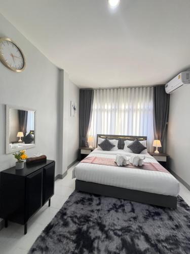 a bedroom with a large bed and a clock on the wall at Ali House Patong in Patong Beach