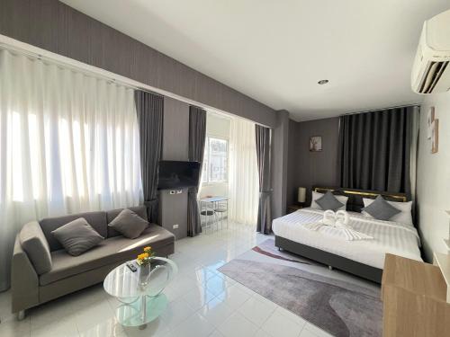 a bedroom with a bed and a couch at Ali House Patong in Patong Beach