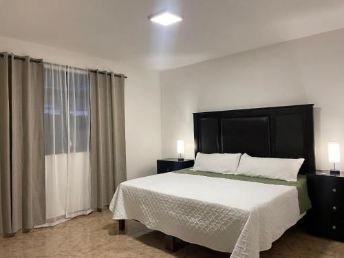 a bedroom with a large bed and a window at Departamento Victoria in San Juan de los Lagos