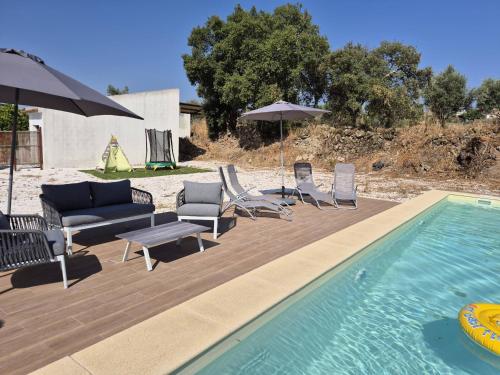 a pool with chairs and umbrellas next to at Luar de Prata by Portus Alacer in Crato