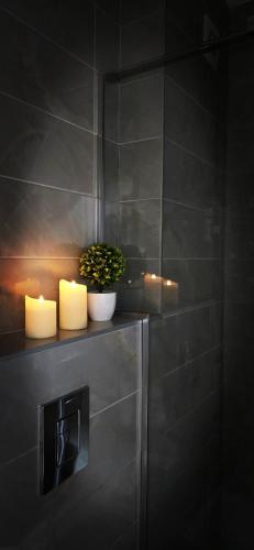 two candles on a shelf in a bathroom at Apartments Ogi in Divčibare