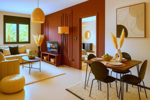 un salon avec une table et des chaises dans l'établissement Appartement Luxe 2 Chambres Vue Directe Jardin Majorelle YSL, à Marrakech