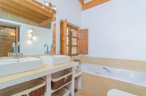 a bathroom with two sinks and a tub at Villa Es Molí des Trenc in Colònia De Sant Jordi