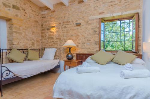 a bedroom with two beds and a window at Villa Es Molí des Trenc in Colònia De Sant Jordi