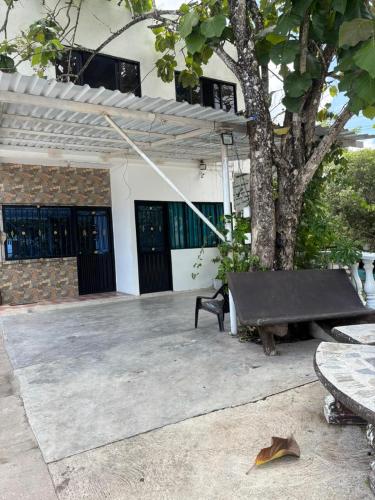 a bench in front of a building with a tree at Santorini colombiano, Doradal Antioquia in Estación El Salto