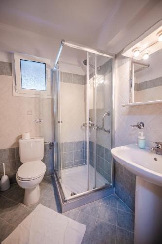 a bathroom with a shower and a toilet and a sink at Spyridoula Resort in Corfu in Gouvia
