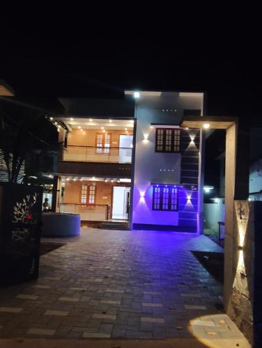 a building with purple lights on it at night at Bluebell Shores -Cozy Stay Near Varkala Beach in Varkala