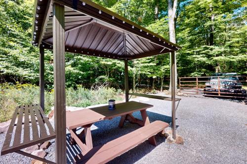 a picnic table and a bench under an umbrella at The Frank Lloyd Wright Home @ Deep Creek, MD in Bittinger