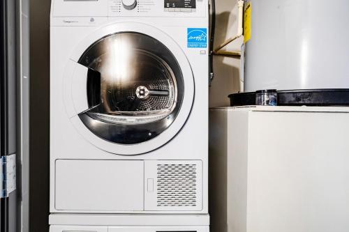a white washing machine sitting next to a refrigerator at Modern-Chic Loft in Heart of Dallas in Dallas