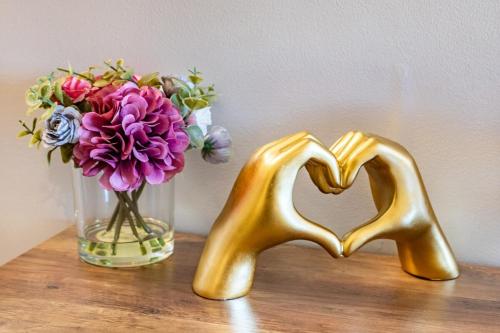 two gold heart shaped chairs sitting next to a vase of flowers at Modern-Chic Loft in Heart of Dallas in Dallas