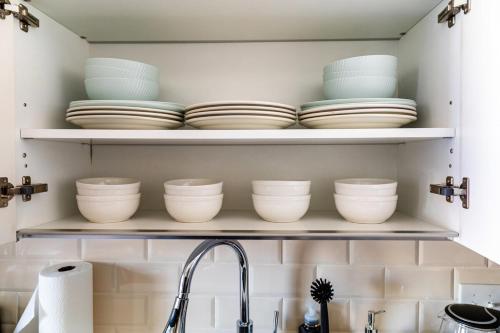 a kitchen shelf with plates and bowls on it at Modern-Chic Loft in Heart of Dallas in Dallas
