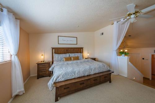 Un dormitorio con una cama y un ventilador de techo. en Symphony Suite, en Wellsona