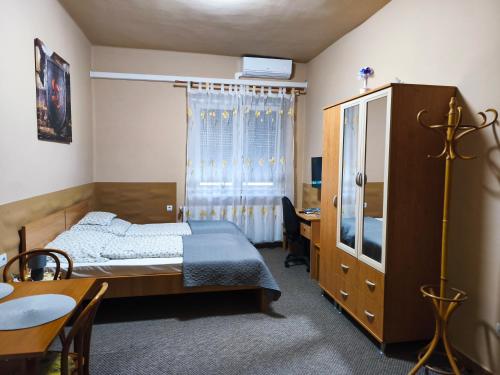 a bedroom with a bed and a desk and a table at Vár-Liget Vendégház in Kisnána