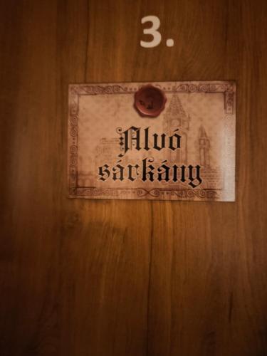 a sign on a wooden door with the number three at Vár-Liget Vendégház in Kisnána