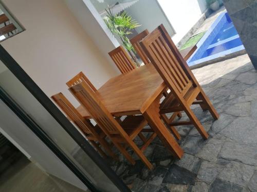 a wooden table and two chairs sitting on a patio at The Coconut tree villa in Dharga Town
