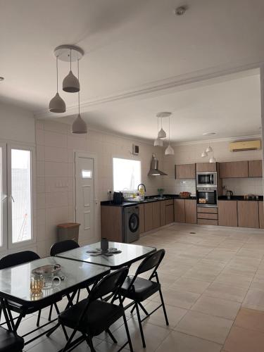 Una cocina y un comedor con mesa y sillas. en Rest Guest house, en Mascate