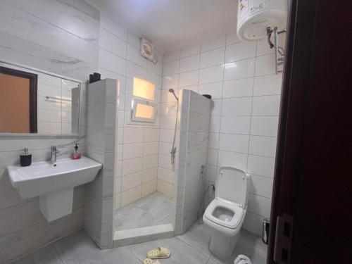 Un baño con lavabo, inodoro y ducha. en Rest Guest house, en Mascate
