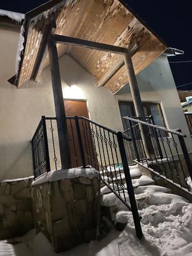 巴库里阿尼Cottage Bakhuta Bakuriani的一座有雪中楼梯的建筑