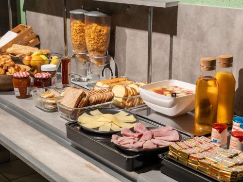 a buffet of food with meats and other foods at ibis budget Le Mans Centre in Le Mans