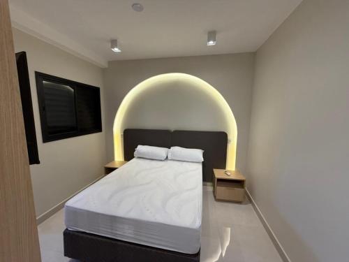 a bedroom with a bed with an arch overhead at High standard apartment, well located in Anápolis