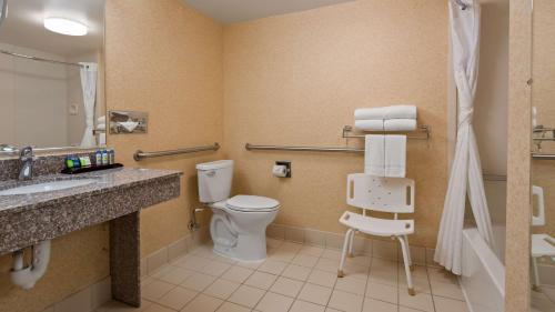 a bathroom with a toilet and a sink and a mirror at SureStay Plus Hotel by Best Western Chicago Lombard in Lombard