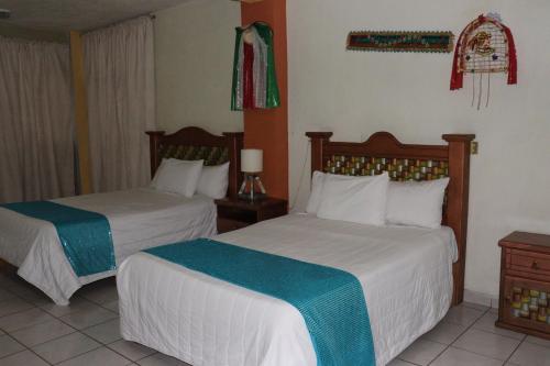 a hotel room with two beds in a room at Hotel Carnaval in Huejotzingo