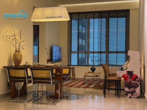 a living room with a dining room table and chairs at Amber Cove Impression City By Heystay Management in Melaka
