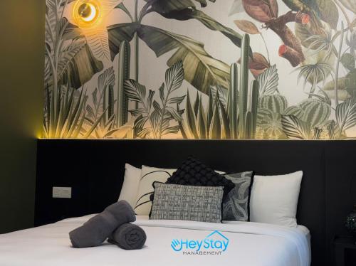 a bedroom with a bed with a mural of plants at Amber Cove Impression City By Heystay Management in Melaka