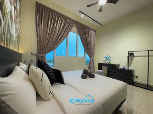 a bedroom with a white bed with a window at Amber Cove Impression City By Heystay Management in Melaka
