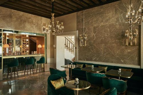 a restaurant with green chairs and tables and a bar at Hotel Gabrielli Venezia - Starhotels Collezione in Venice