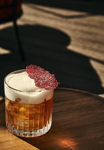 a drink sitting on a wooden table with a red topping at Hotel Gabrielli Venezia - Starhotels Collezione in Venice