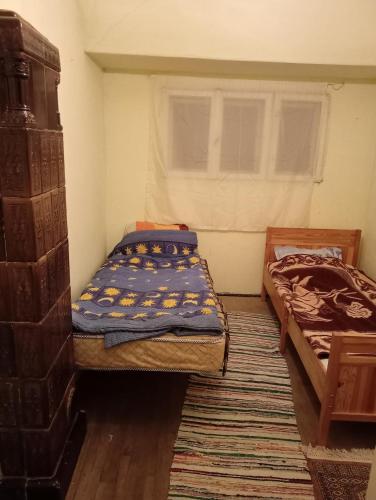 a small bedroom with two beds and a window at Școala Zamolxiană in Predeal