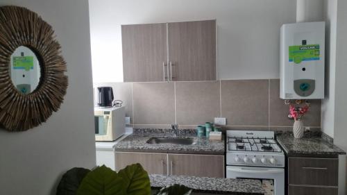 a kitchen with a sink and a stove top oven at Garage y Gimnasio Depto Ideal Villa Dolores in Villa Dolores