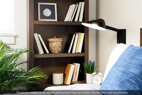 a book shelf filled with books next to a couch at InTown Suites Extended Stay Atlanta GA - Lithia Springs in Lithia Springs