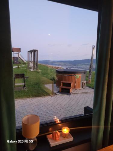 a window with a view of a backyard with a hot tub at Chaty u Taty in Szlembark