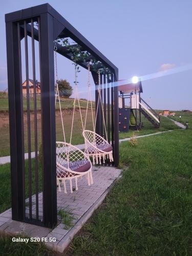 a playground with two chairs and a swing at Chaty u Taty in Szlembark