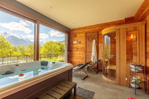 a bath tub in a room with a large window at Affittacamere Verger Plein Soleil in Saint-Pierre