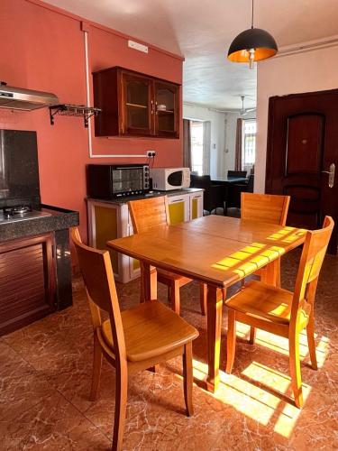 a kitchen with a wooden dining room table and chairs at Bonzour Tropical Apartments l 2 Bedrooms l Pool l Equipped kitchen l Cosy l Trou aux Biches l Mauritius in Trou aux Biches