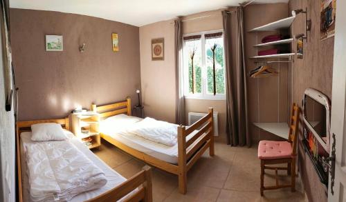 Un dormitorio pequeño con dos camas y una ventana. en Les chênes vert, en Le Beausset