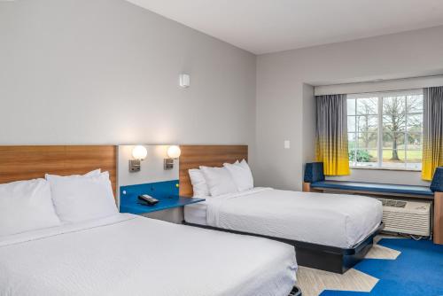 a hotel room with two beds and a window at Microtel Inn and Suites Montgomery in Montgomery