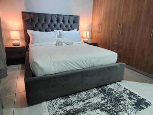 a bedroom with a large bed with a stuffed animal on it at Home Sweet Luxe Stays in Lobamba