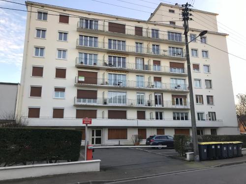 a large white building with windows and a parking lot at Studio 29 in Troyes