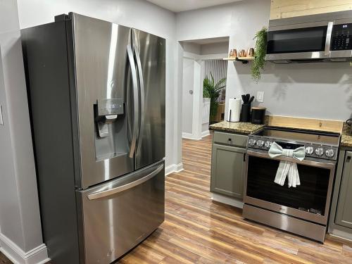 a kitchen with a stainless steel refrigerator and a stove at Unique 3Bd 2Ba GAME ROOM mins to Downtown in Winston-Salem