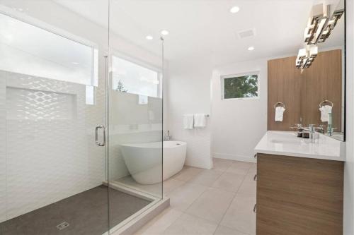 a bathroom with a glass shower and a tub and a sink at New House with Chef's Kitchen and Spa-like Suite in Seattle