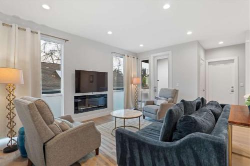 a living room with a couch and chairs and a tv at New House with Chef's Kitchen and Spa-like Suite in Seattle
